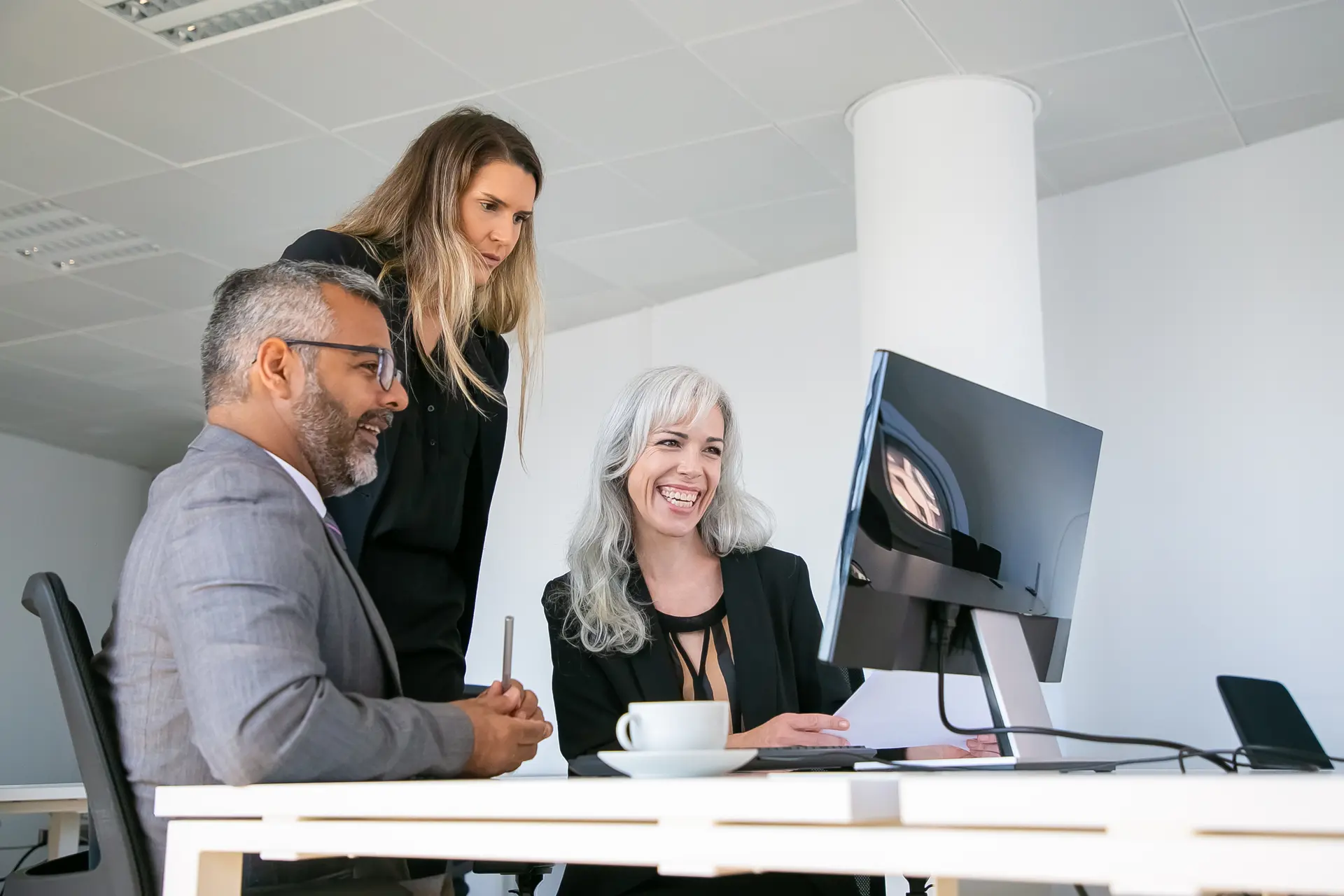 Modern business team collaborating around a laptop